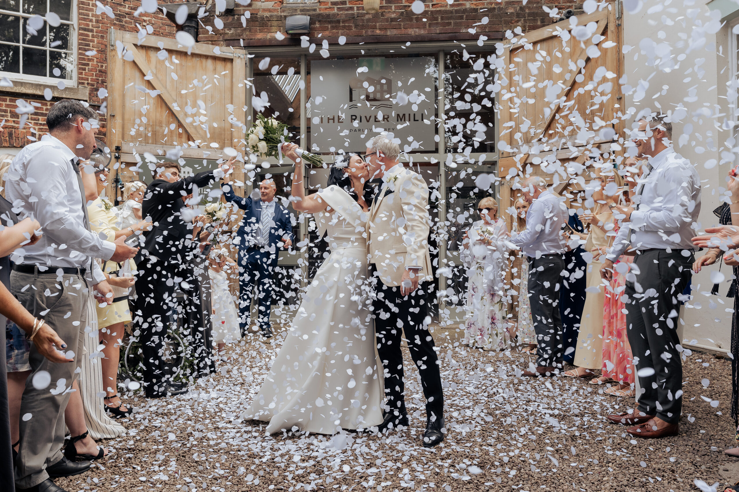 lots of confetti on the bride and groom at the River Mill wedding venue in Derby